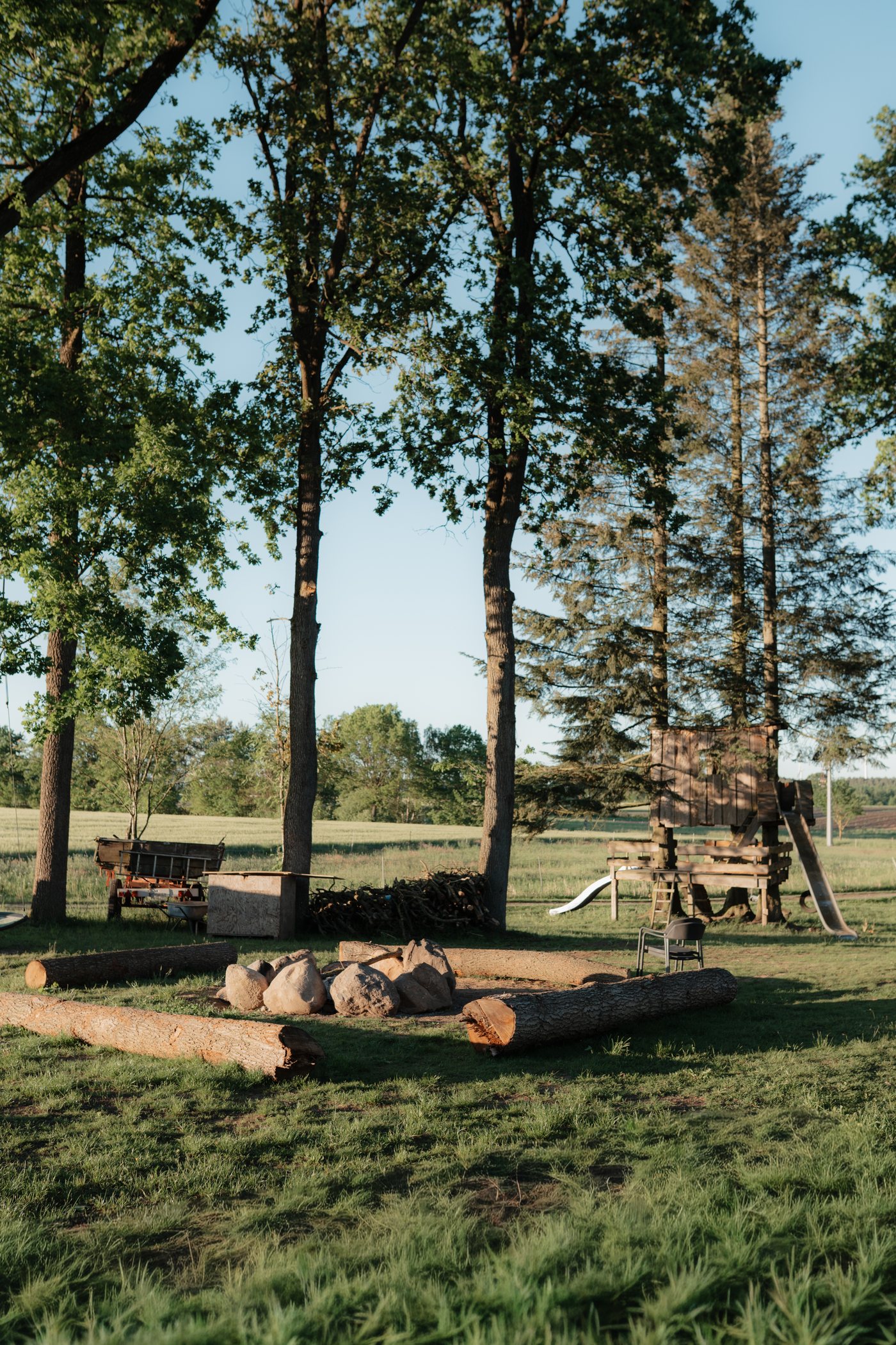 Feuerstelle und Spielplatz unter alten Bäumen auf dem Eichenhof